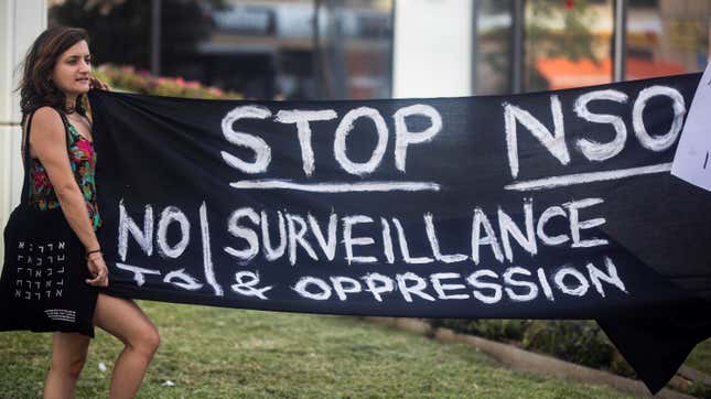 A protester holds a banner during a protest attended by about a dozen people outside the offices of the Israeli cyber firm NSO Group in Herzliya near Tel Aviv, Israel July 25, 2021.