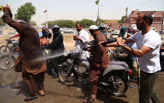 A man sprays motorists with water on a road in Karachi.