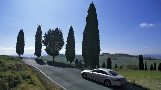 A photo of a silver Mercedes-Benz CLS 63 driving on a road. 