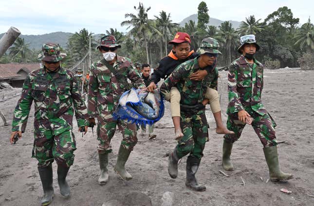 Members of a search and rescue team carry a villager during an operation at the Sumberwuluh village.