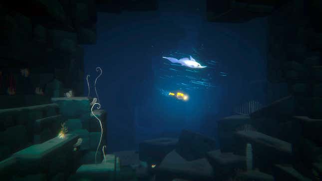 A diver swims with a fish deep underwater.