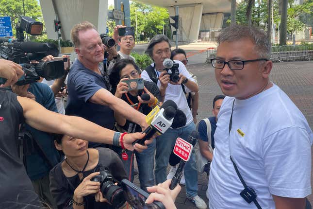 Hong Kong Journalists Association&#39;s Chairman Ronson Chan, right, speaks to reporters outside a court building in Hong Kong Monday, Sept. 25, 2023. The chairman of Hong Kong’s leading journalist group was found guilty of obstructing a police officer on Monday in a court case that sparked concerns about the city&#39;s declining press freedom. (AP Photo/Alice Fung)