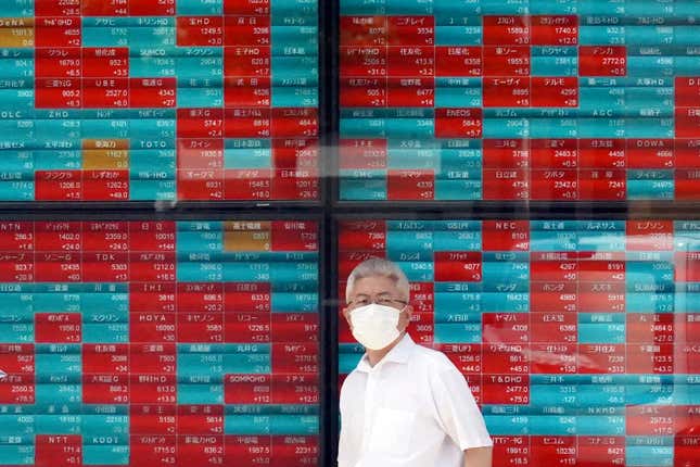 FILE - A person stands in front of an electronic stock board showing Japan&#39;s Nikkei 225 index at a securities firm Monday, Sept. 11, 2023, in Tokyo. Asian shares mostly sank Tuesday, Sept. 26, over worries about a possible U.S. government shutdown and the troubled Chinese economy.(AP Photo/Eugene Hoshiko, File)