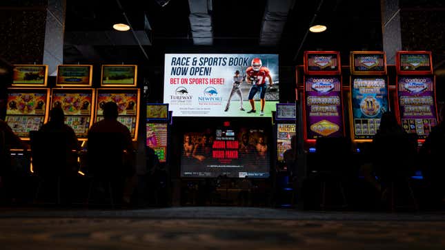 FILE - A huge TV screen at the entrance of Churchill&#39;s Bourbon &amp; Brew Bar &amp; Grille, flanked by electronic gaming machines, promotes sports betting at Turfway Park Racing &amp; Gaming, Dec. 22, 2023, in Florence, Ky. A bill that would allow sports betting in Georgia under the purview of the state lottery advanced out of committee Tuesday, Jan. 30, 2024, moving on to the full Senate for more debate. (AP Photo/Carolyn Kaster, File)