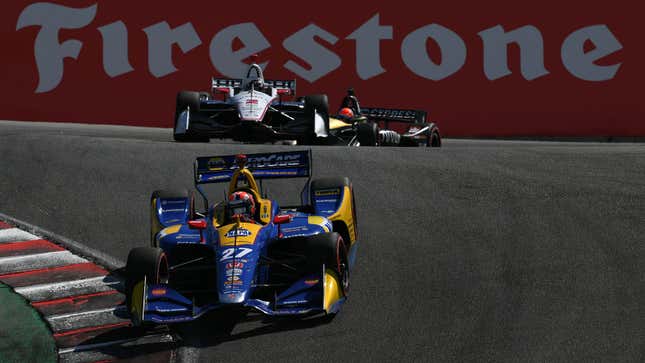 A photo of Indycars racing round Laguna Seca in California. 