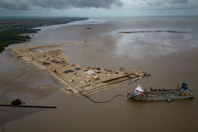 FILE - A ship creates an artificial island by extracting offshore sand to create a coastal port for offshore oil production at the mouth of the Demerara River in Georgetown, Guyana, April 12, 2023. Guyana opened bids on Sept. 12, 2023 for 14 offshore oil blocks available for exploration and development as the South American country seeks to ramp up oil production. (AP Photo/Matias Delacroix, File)