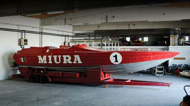 A photo of the red racing boat, which says "Miura" down the side 