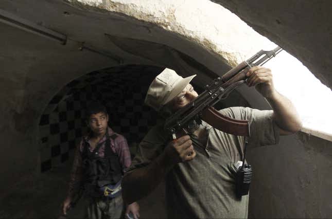 A Free Syrian Army fighter aims his weapon from a defensive position in the old city of Aleppo on Jul. 3, 2013.