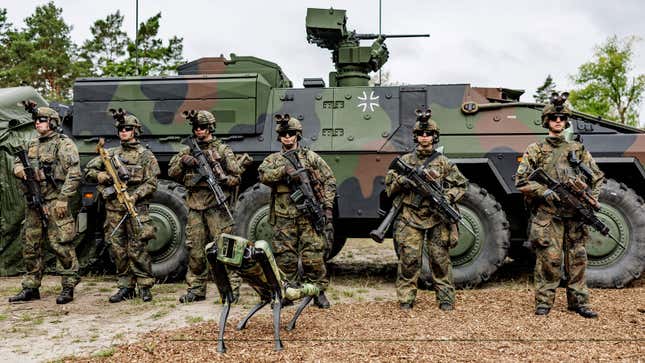 A photo of a robot dog training with a group of soldiers. 