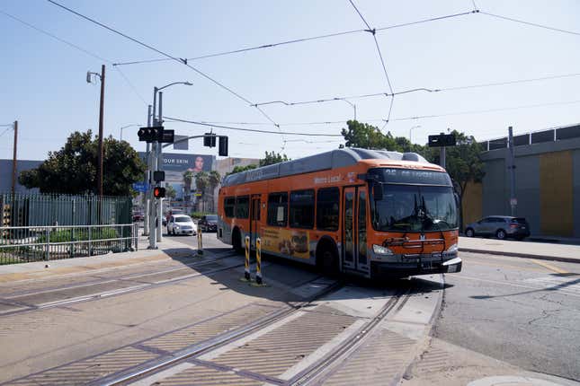 A LA Metro bus driving across train tracks