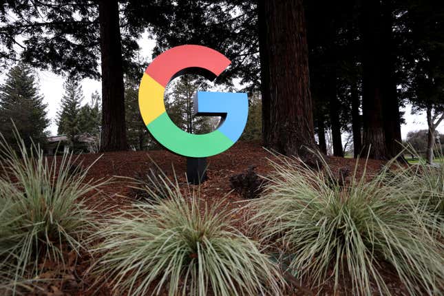 multicolor Google 'G' on display outside above red mulch and some snake plants