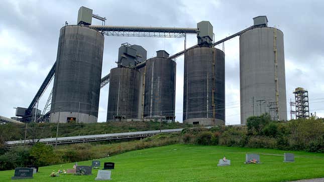 A coal mining facility sits behind headstones in a graveyard in southwest Pennsylvania.
