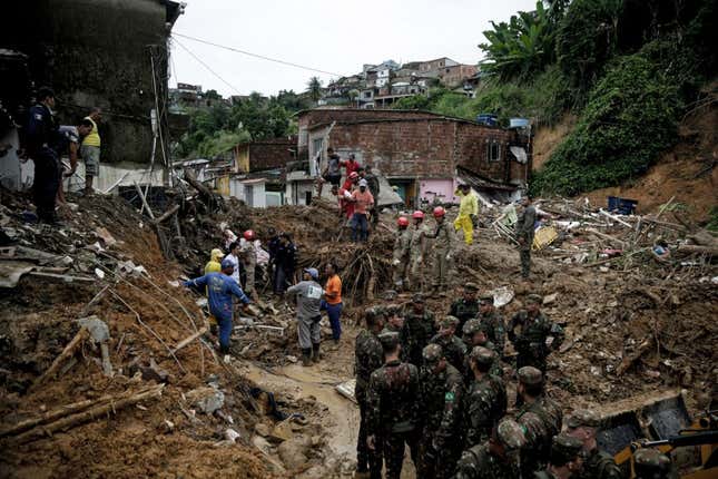 Soldiers, firefighters, and residents search for victims a day after a landslide in the community Jardim Monte Verde in Brazil.