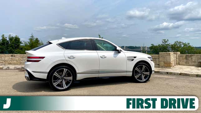 Vue latérale d’un coupé GV80 blanc garé devant une vue panoramique