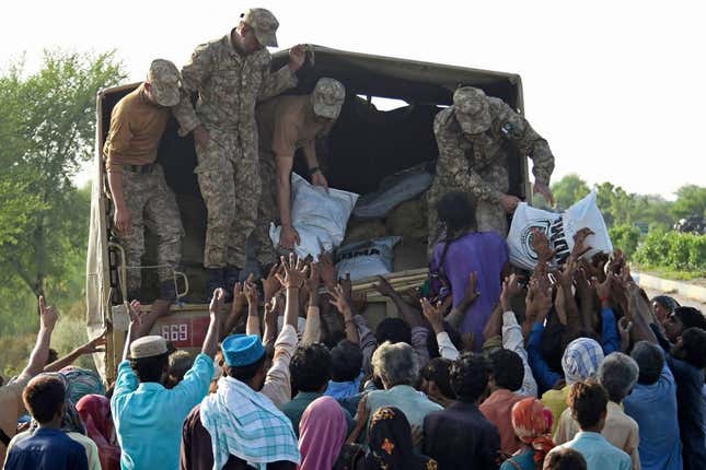 Army soldiers distribute relief food bags to flood-affected people in Shikarpur of Sindh province on August 28, 2022.