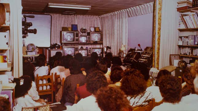 Women with permed hair watch television in the 1980s.