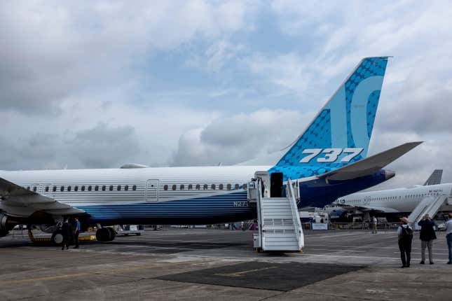 A white and blue plane with "737" written on the tail on a tarmac