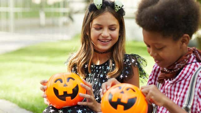 Kids looking in trick or treat buckets on halloween