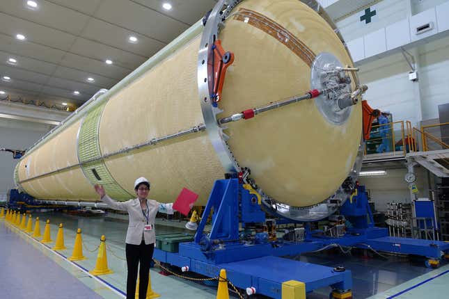 A Mitsubishi Heavy Industries staff member stands next to the top of the first stage of a H3 rocket, inside the Mitsubishi Heavy Industries’ Nagoya Aerospace Systems Works Tobishima Plant in Tobishima, Aichi prefecture Thursday, March 21, 2024. (AP Photo/Mari Yamaguchi)