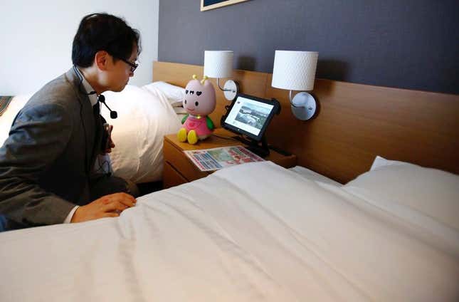 A hotel staffer talks with the concierge robot “Chu-ri-Robo.”