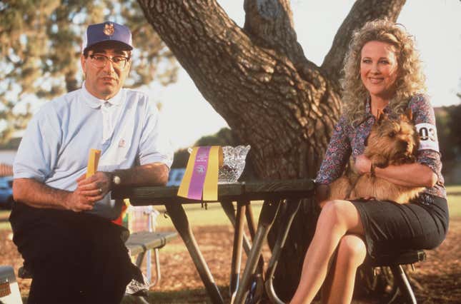 Eugene Levy, left, and Catherine O'Hara, right, sit at a picnic table outside with a tree in the background. 