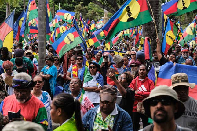 Protesters wave flags of the Socialist Kanak National Liberation Front  (FLNKS)  during a demonstration against the enlargement of the  electorate for the forthcoming provincial elections in New Caledonia, in  Noumea, on April 13, 2024.