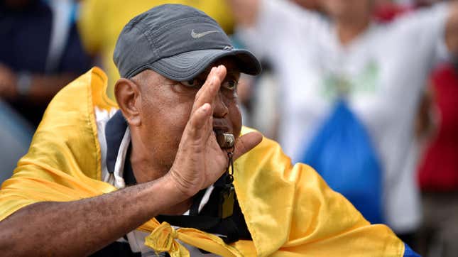 A man uses a whistle while using Ecuador's national flag as a cape during a May Day rally, in Guayaquil, Ecuador May 1, 2023. 