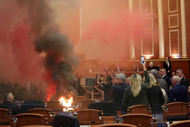 Democratic lawmakers throw flares during a parliament session in Tirana, Albania, Monday, Nov. 20, 2023. Albanian opposition lawmakers disrupted the Parliament&#39;s session again on Monday to protest against what they say is increasingly authoritarian rule by the governing Socialists. (AP Photo/Florian Abazi)