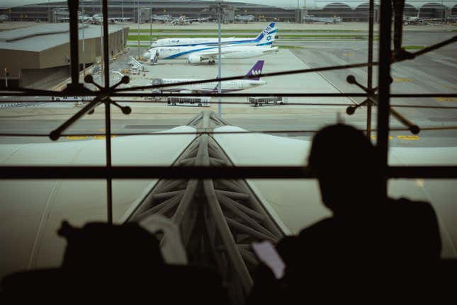 A passenger sits at the observation deck at Suvarnabhumi Airport watching the docked airplanes as a global IT disruption caused by a Microsoft outage and a Crowdstrike IT problem combine to affect users on July 19, 2024 in Bangkok, Thailand.