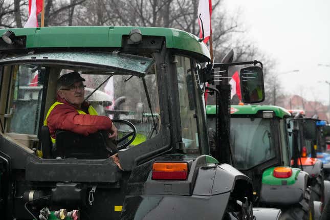 Polish farmers, angry at EU agrarian policy and cheap Ukraine produce imports which, they say, are undercutting their livelihoods, drive their heavy-duty tractors in protest outside the office of the regional governor, in Poznan, western Poland, Friday Feb. 9, 2024. (AP Photo/Czarek Sokolowski)