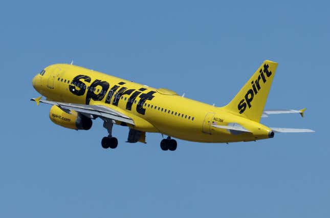 Yellow Spirit Airlines plan flying in a cloudless blue sky