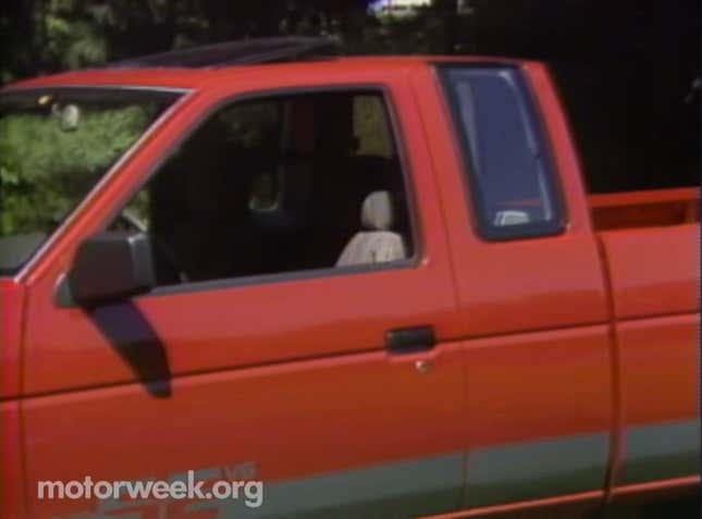 A Nissan Hardbody extended cab. The rear glass sits higher than the front window and curves into the roof.