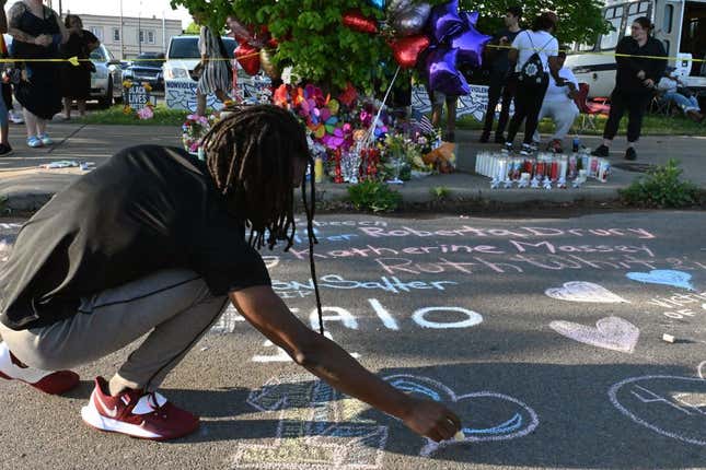 People leave messages at a makeshift memorial near a Tops Grocery store in Buffalo, New York, on May 15, 2022, the day after a gunman shot dead ten people.