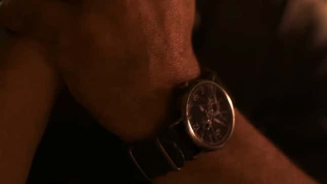 A close up of a character's wrist shows a broken watch.