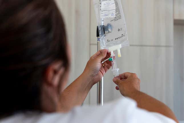 Un cuidador controla una infusión - foto de stock