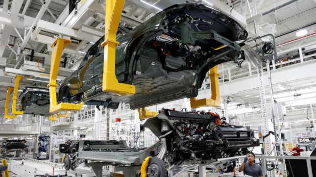 An employee works on an assembly line at startup Rivian Automotive's electric vehicle factory in Normal, Illinois.