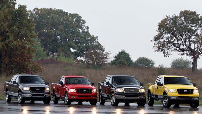 A photo of four Ford pickup trucks in the rain. 