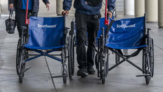 A photo of someone pushing two Southwest Airlines wheelchairs. 