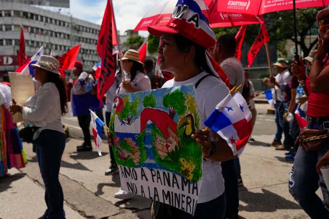 A woman holds a banner with a message sthat read in Spanish: &quot;I love Panama, Not mining&quot;, during a protest against a mining contract between the Panamanian government and the Canadian mining company First Quantum, in Panama City, Friday, Nov. 3, 2023. (AP Photo/Arnulfo Franco)