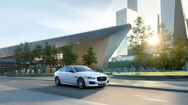 A white Jaguar XE sedan drives in Rotterdam