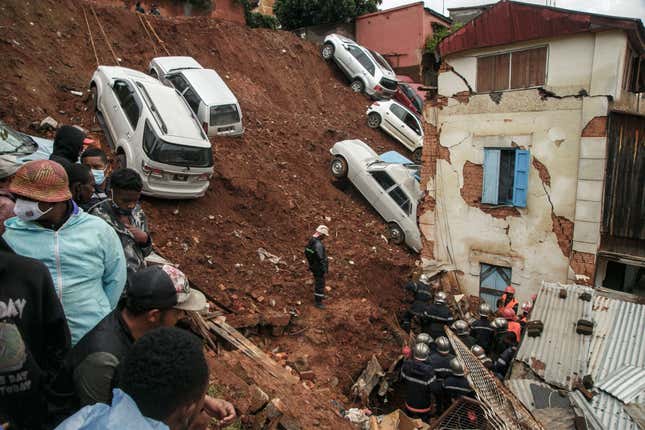 Firefighters search through rubble after a car park housing several private cars collapsed on houses following the heavy rains of the last few days in the Ankadifotsy neighbourhood of Antananarivo on January 24.