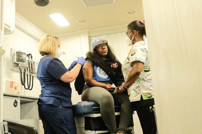 DETROIT, MICHIGAN, UNITED STATES - 2021/07/21: Health Care Workers from the Detroit Health Department administer a dose of the Pfizer Covid-19 vaccine to a patient during mobile vaccination clinic at East English Village High School. Vaccination Clinics are being held at various dates through the rest of July and into August at 3 different public high schools in Detroit, Michigan. 