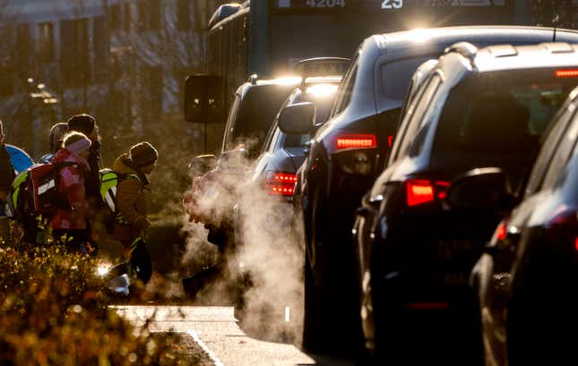 FILE - Cars release exhaust fumes as children head to school in Frankfurt, Germany, Feb. 27, 2023. Most passenger cars in the European Union still emit the same quantity of CO2 as 12 years ago, the European Union’s auditing agency warned on Wednesday, Jan. 24, 2024. The European Court of Auditors said the 27-nation bloc must “shift up the gear” to come close to a zero-emissions car fleet, with electric vehicles playing a crucial role. (AP Photo/Michael Probst, File)