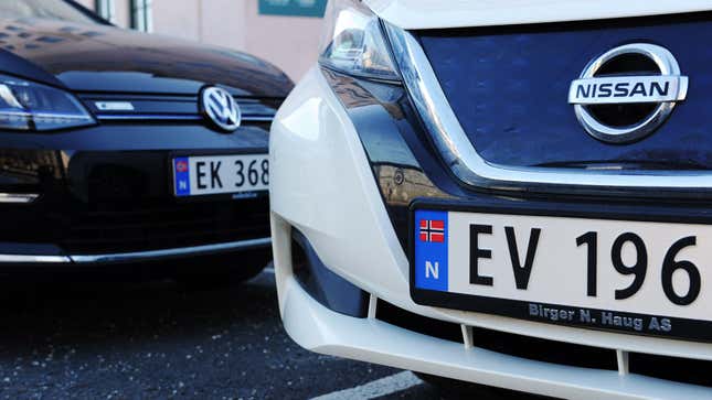 Electric cars are parked in front of an office building. third of all newly registered vehicles in the country are electrically powered. All EV, EL and Ek cars are electric cars in Norway.