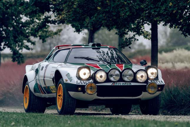 An Alitalia-liveried Lancia Stratos rally car on a gravel road.