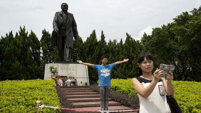 Visitors pose in front of a statue of the late Chinese leader Deng Xiaoping in Shenzhen, in southern China's Guangdong province, August 19, 2014.