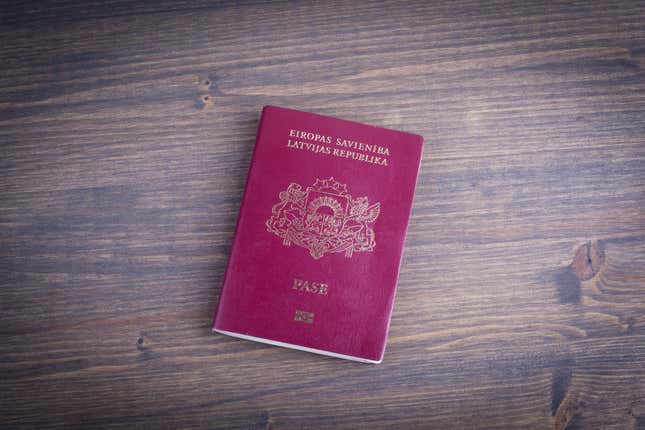 Latvia's passport on a dark wood background