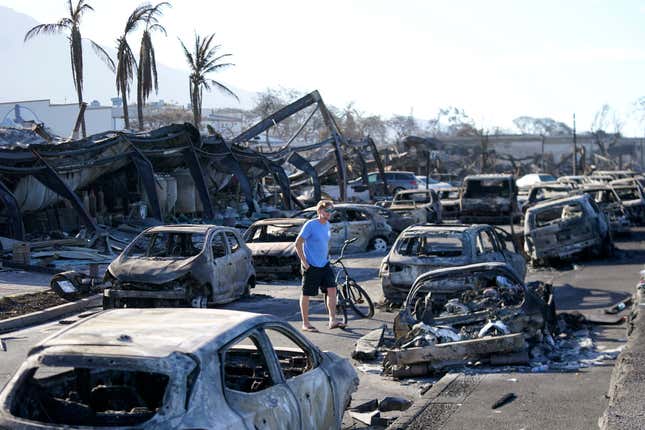 FILE - A man walks through wildfire wreckage Friday, Aug. 11, 2023, in Lahaina, Hawaii. Nearly a month after the deadliest U.S. wildfire in more than a century killed scores of people, authorities on Maui are working their way through a list of the missing that has grown almost as quickly as names have been removed. Lawsuits are piling up in court over liability for the inferno, and businesses across the island are fretting about what the loss of tourism will mean for their futures. (AP Photo/Rick Bowmer, File)