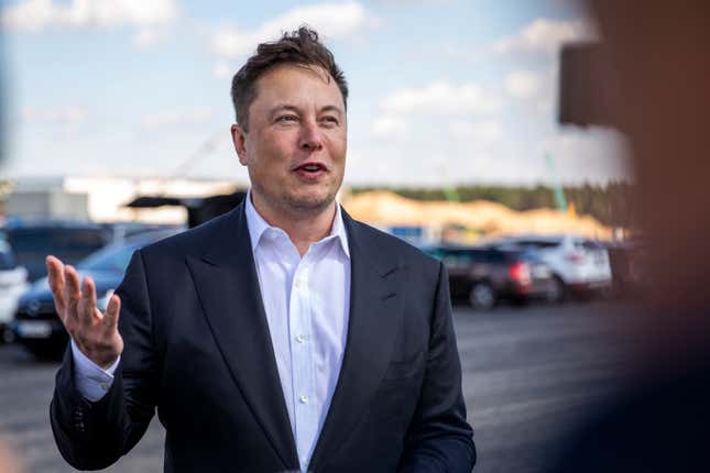 Elon Musk with his hand raised, confused