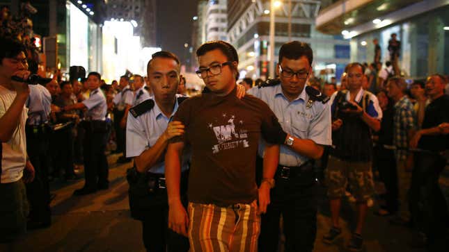 Police remove a pro-democracy protester during confrontations with anti-Occupiers in Mong Kok.